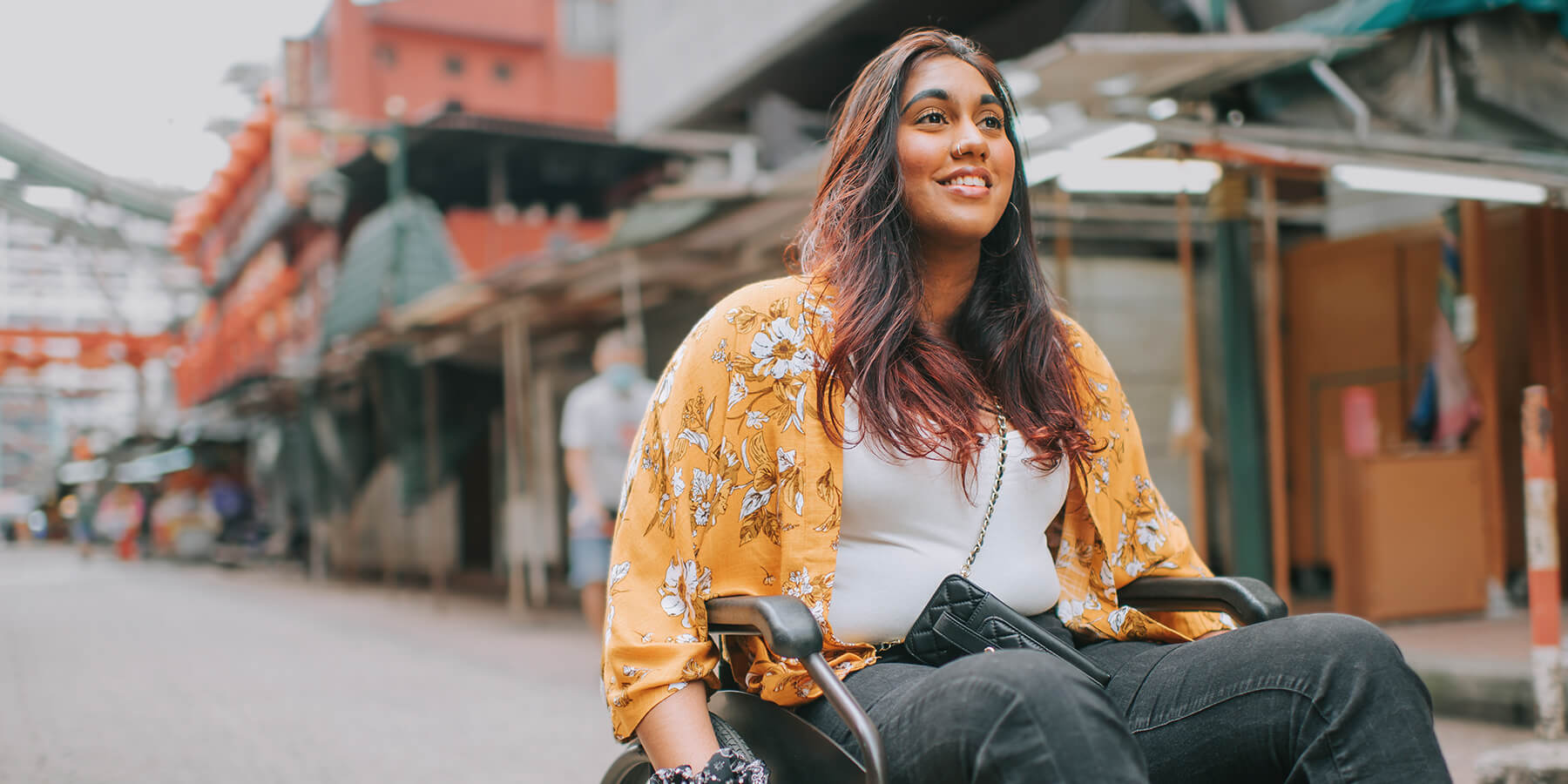Smiling woman in a wheelchair outdoors, representing confidence and freedom after LASIK eye surgery.