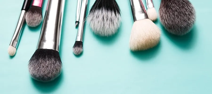 Assortment of makeup brushes lying down on a table.